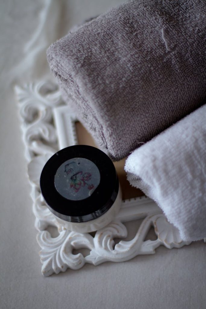 A luxurious spa arrangement with rolled towels and a container on a decorative frame.